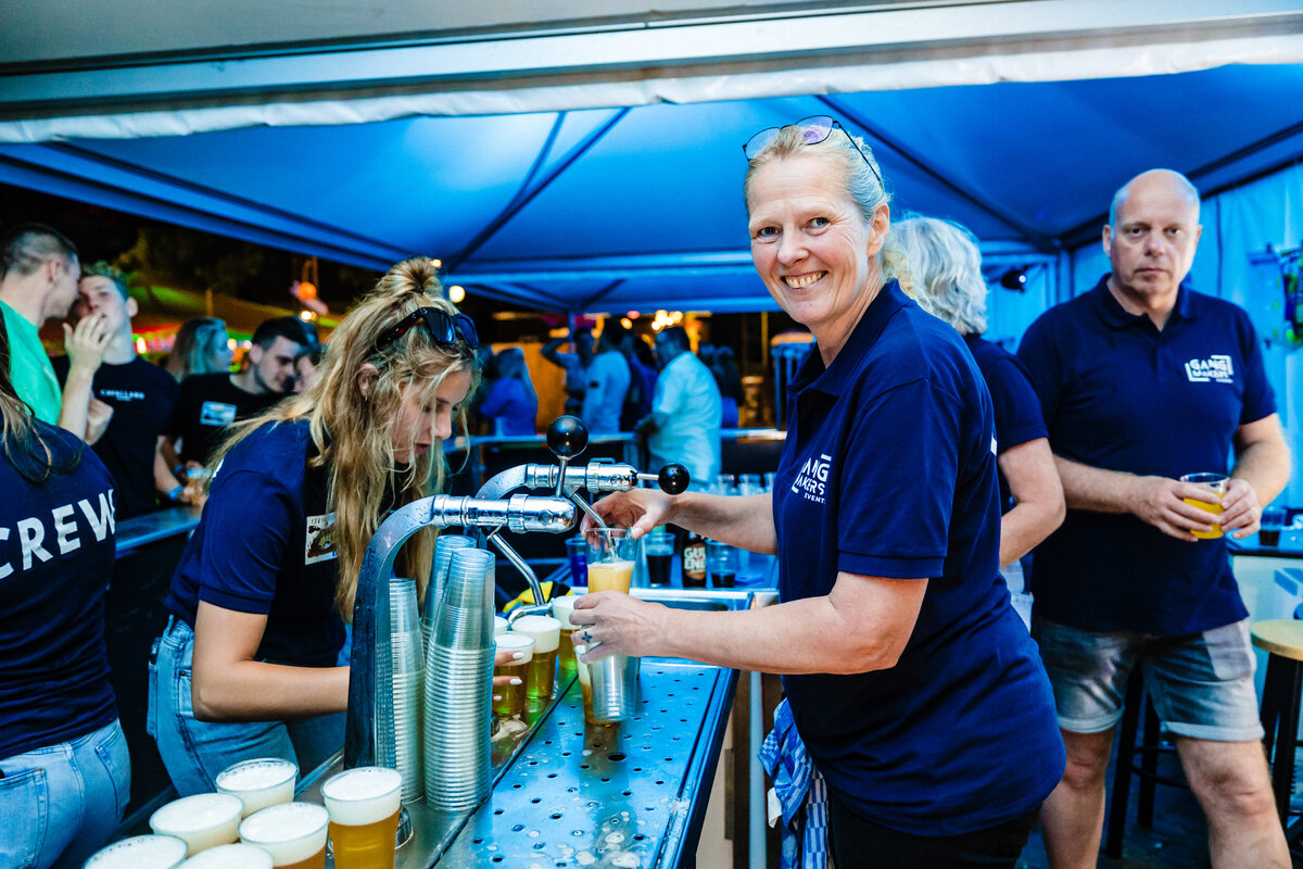 Vrijwilligers van Pleinfeest Ottersum tappen bier achter de bar